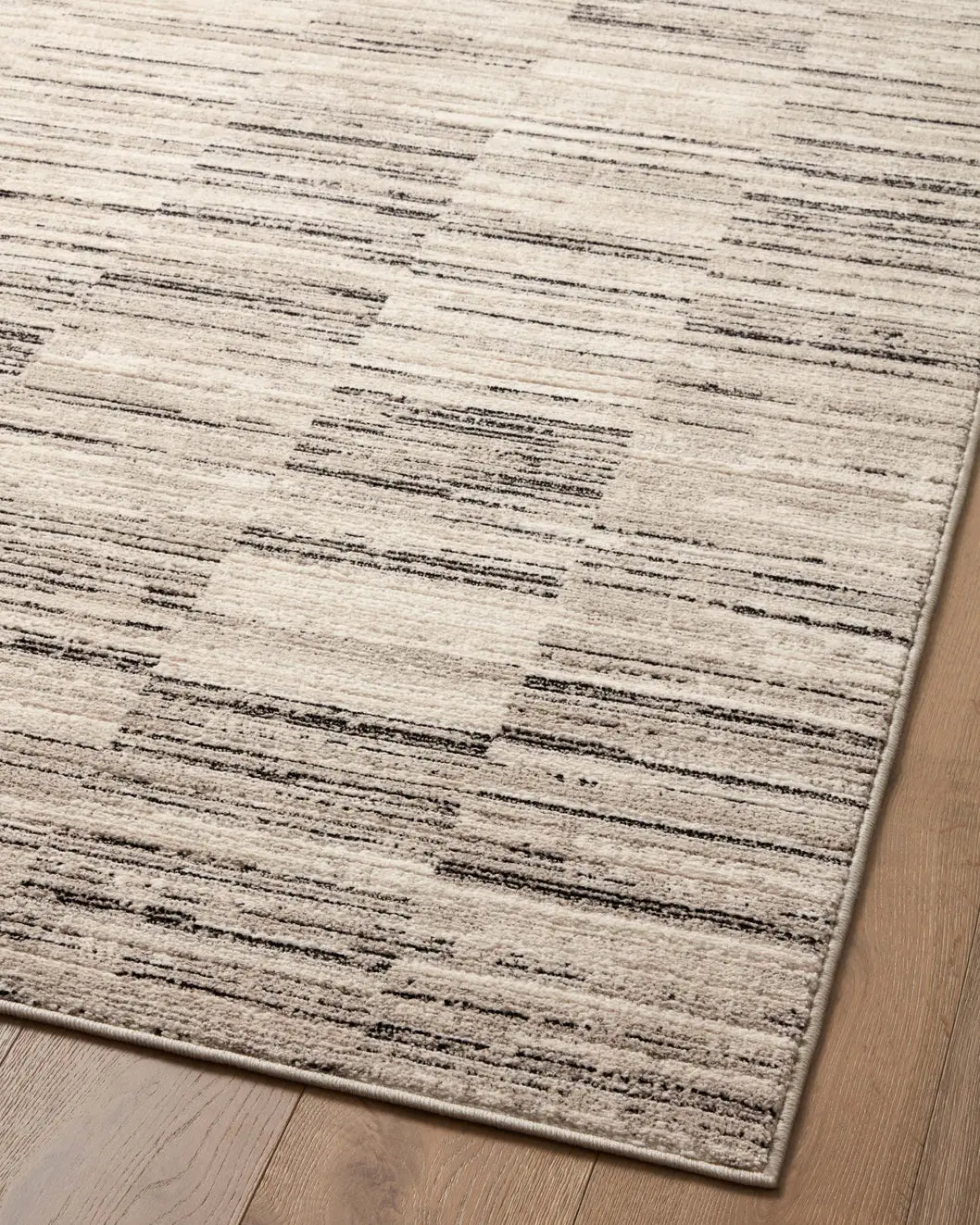 Loloi Darby Dar-01 Charcoal/Sand Rug - angled corner on wood