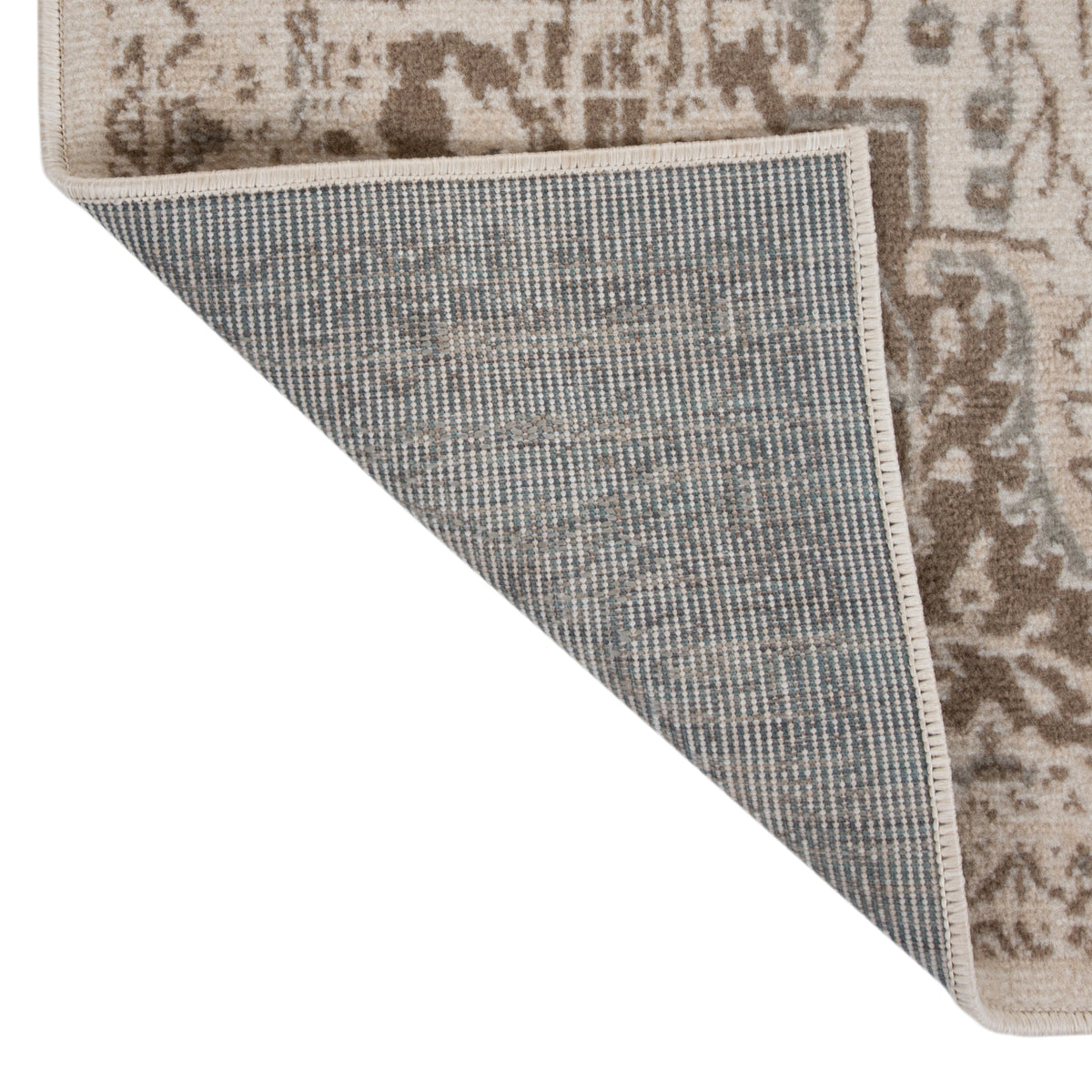 Rectangle rug corner with stitched border and patterned face over blue-gray backing.