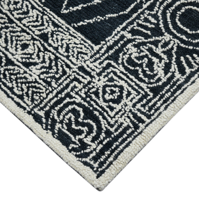 Rectangular area rug with charcoal background and white geometric medallion pattern