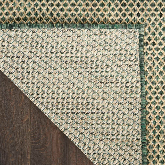 Green and beige rug corner with diamond lattice pattern and fringeless edge detail