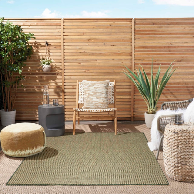 Green outdoor-style rug with repeating diamond lattice pattern and flat woven texture
