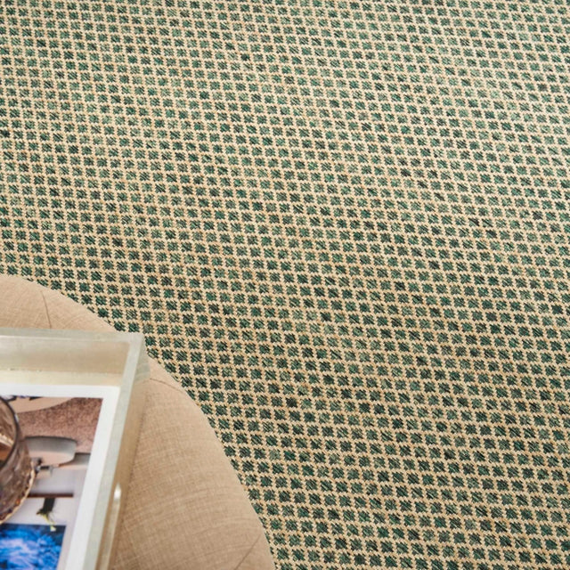Green rug with repeating diamond lattice pattern and visible edge near furniture