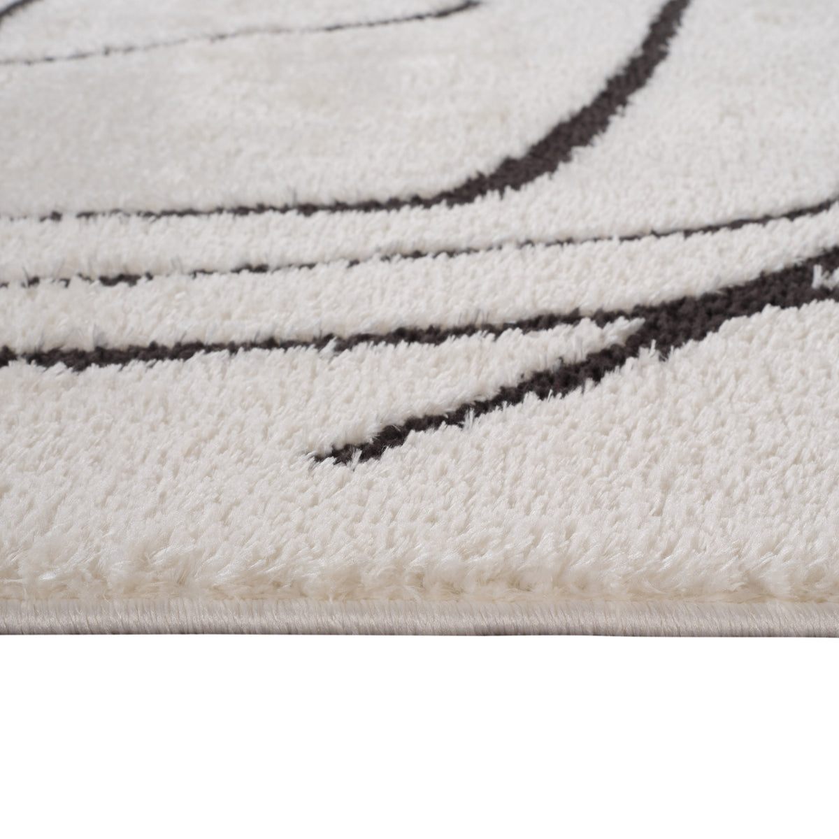 Ivory area rug showing short textured pile and black stitched geometric border lines