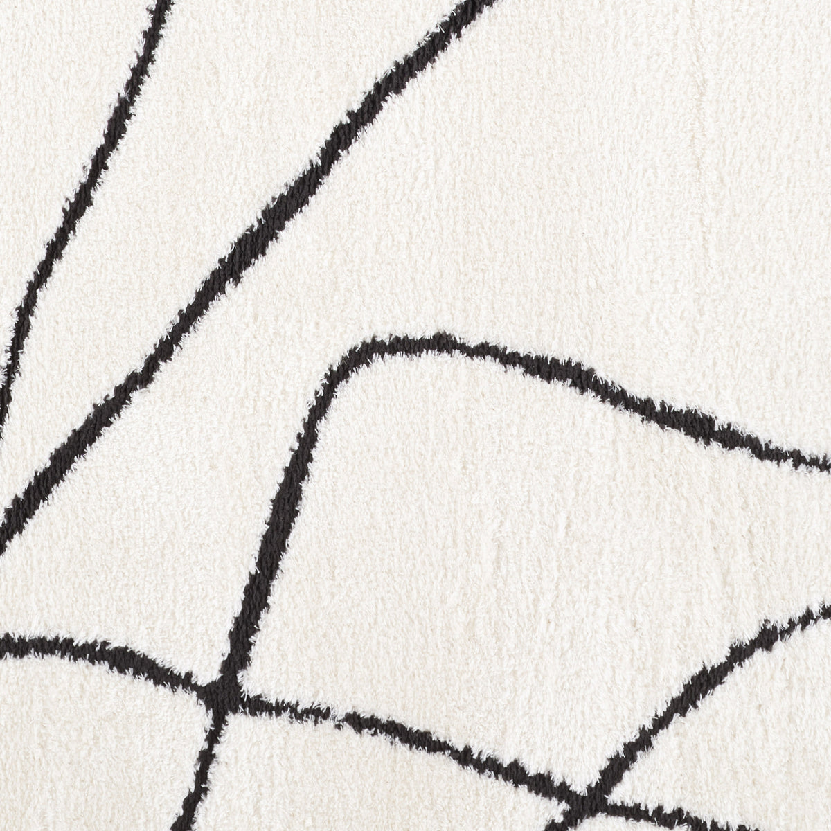 Ivory area rug close-up with connected black geometric curves and corners