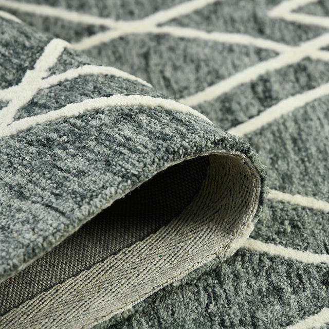 Rolled edge detail: gray rug with off-white lines and textured weave binding