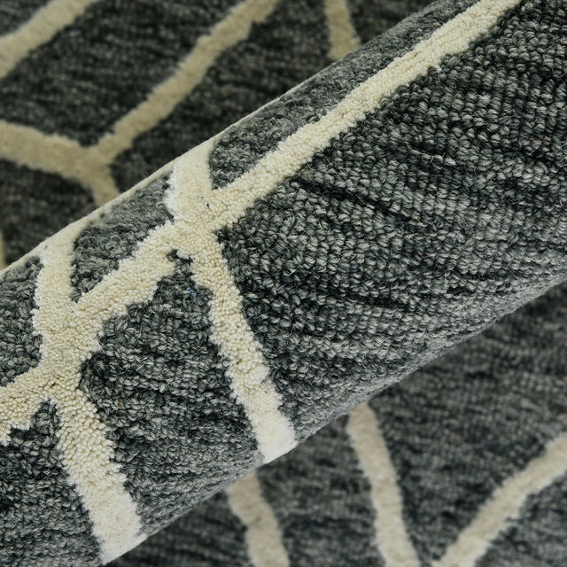 Rug pile detail in gray with off-white stripe accents over geometric design