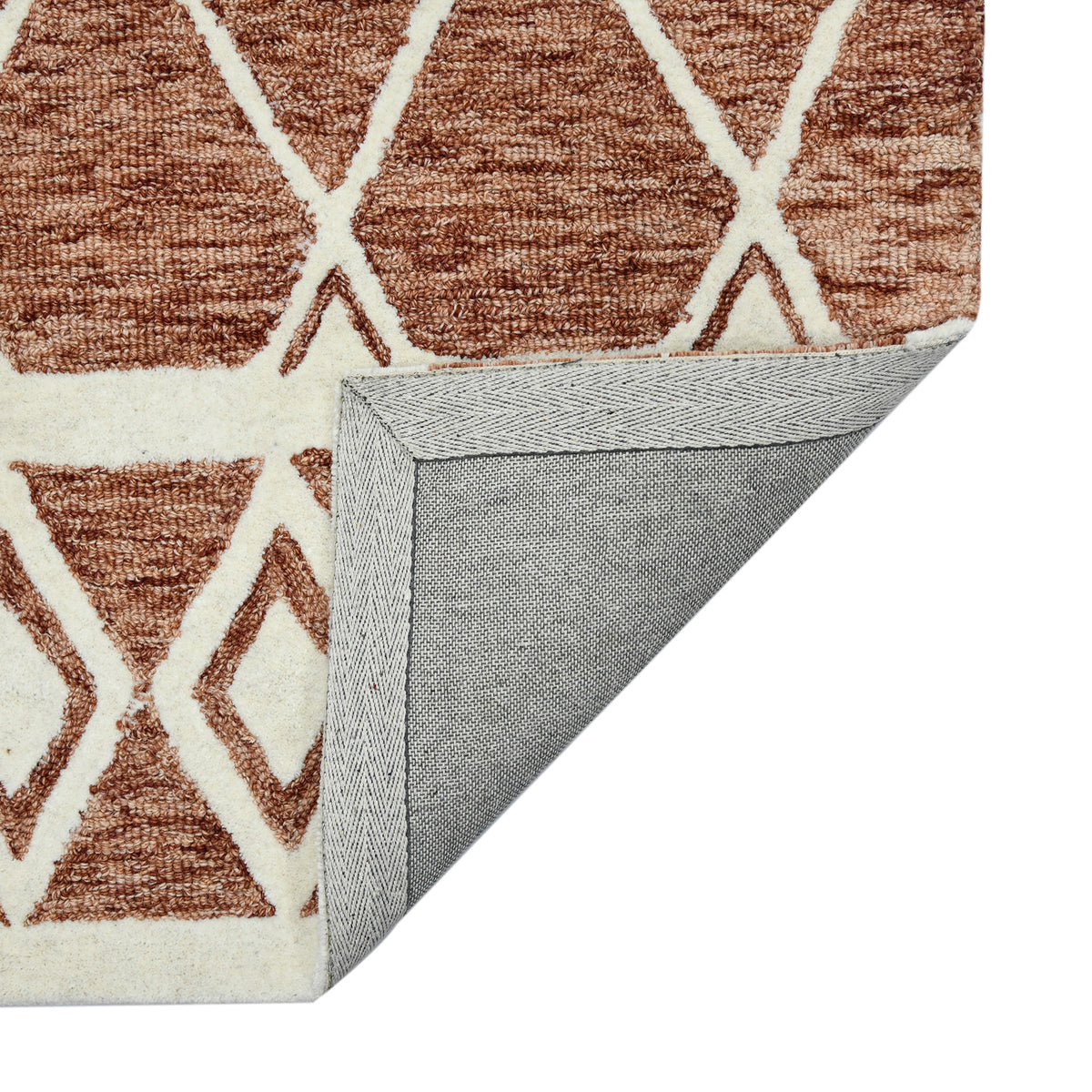 Geometric rust area rug with cream X and diamond shapes, folded edge detail
