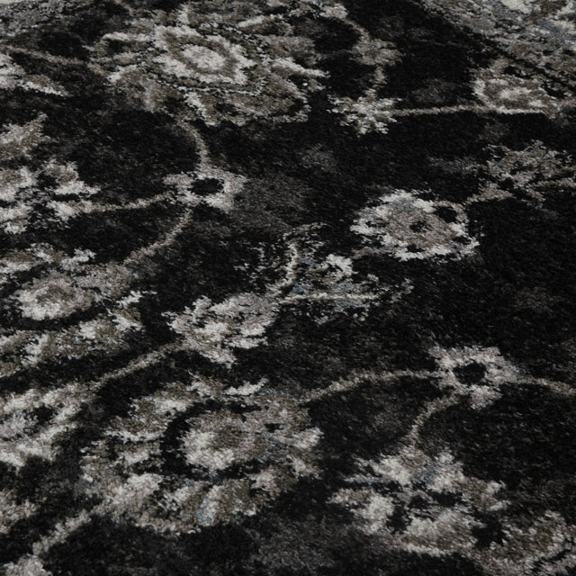 Black and ivory patterned area rug with distressed geometric motifs