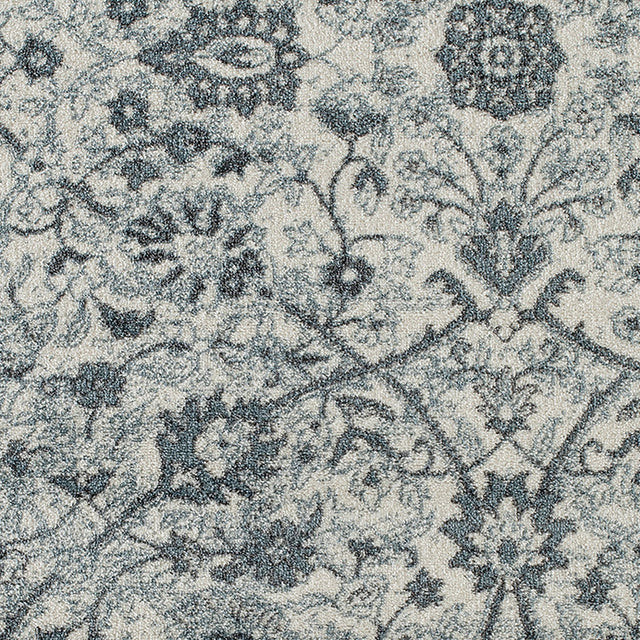 Close-up of light blue floral area rug with dense dark motif detailing