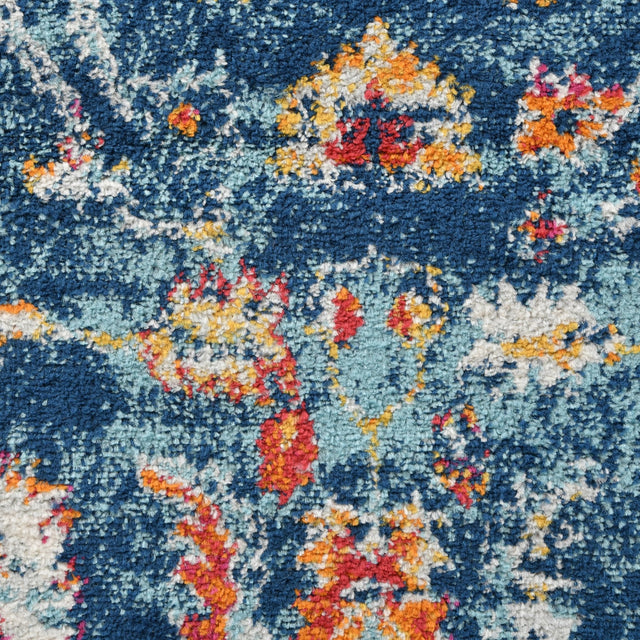 Navy short-pile area rug with multicolor distressed floral and speckled pattern