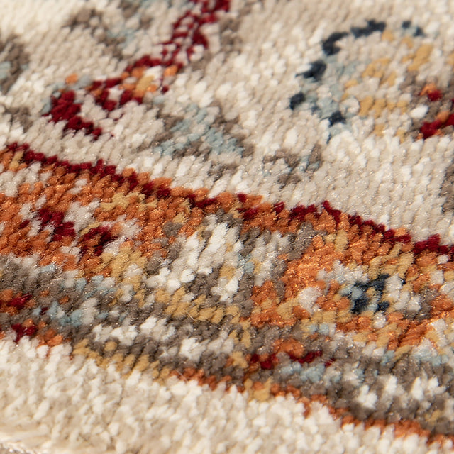 Ivory area rug with dense multicolor abstract pattern in blue, orange, and red tones