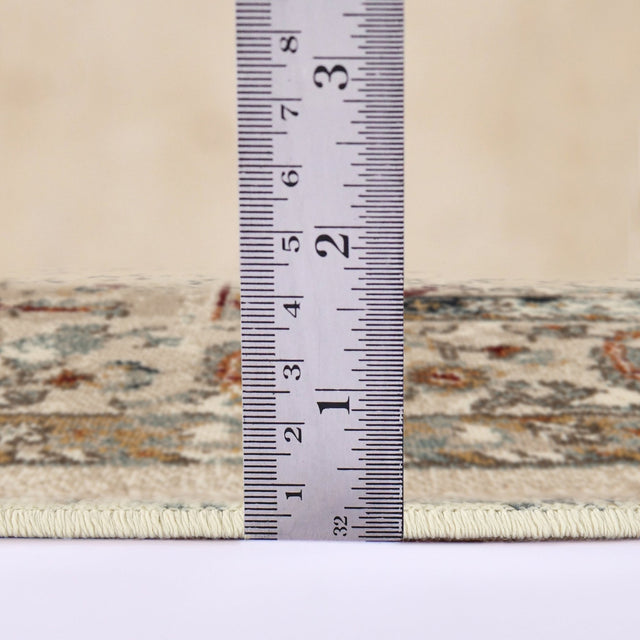 Ivory multi-color area rug shown with measurement tape across the border edge