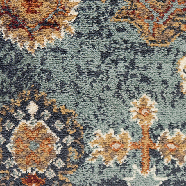 Close-up of multicolor distressed pattern on teal blue area rug with textured low pile
