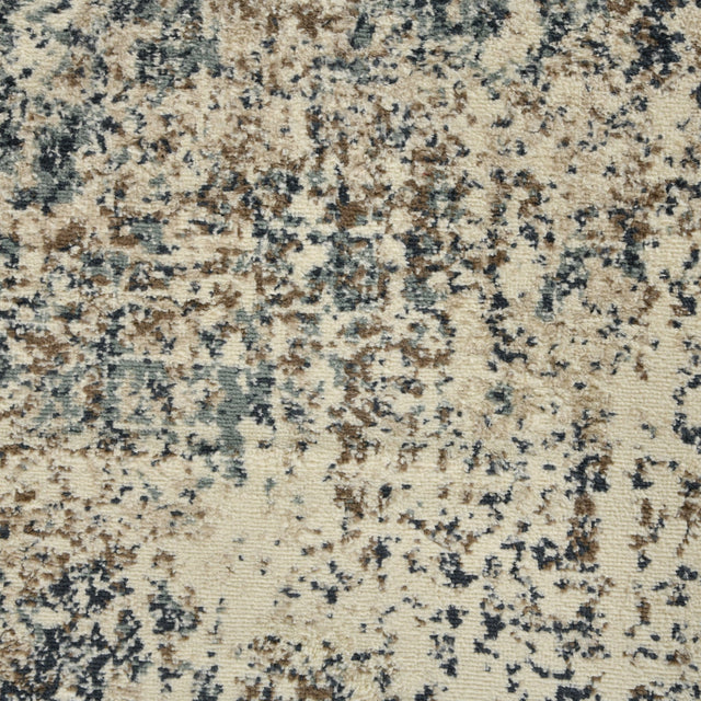 Close-up of speckled area rug surface in cream, tan, and blue flecks