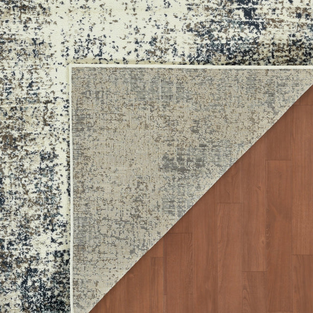 Contemporary area rug corner showing cream base with blue-gray textured motif