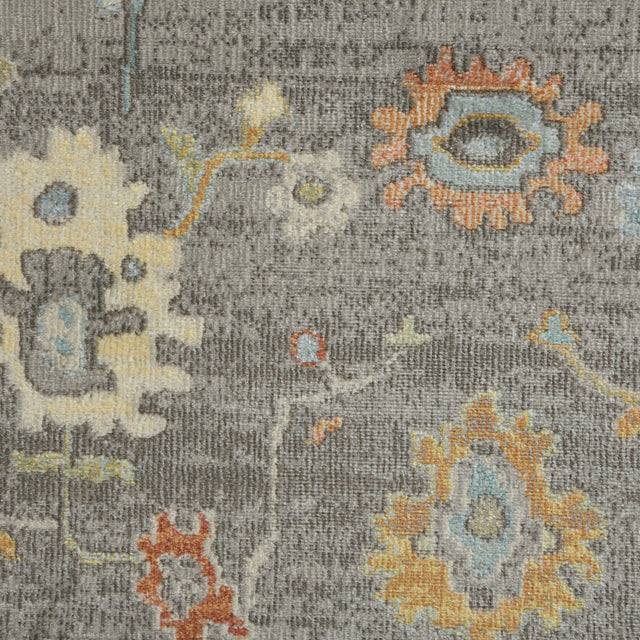 Taupe rug surface close-up with colorful geometric elements and distressed patterning.