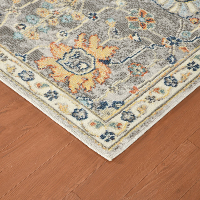Gray rectangular area rug with border trim, multicolor floral medallions on hardwood floor
