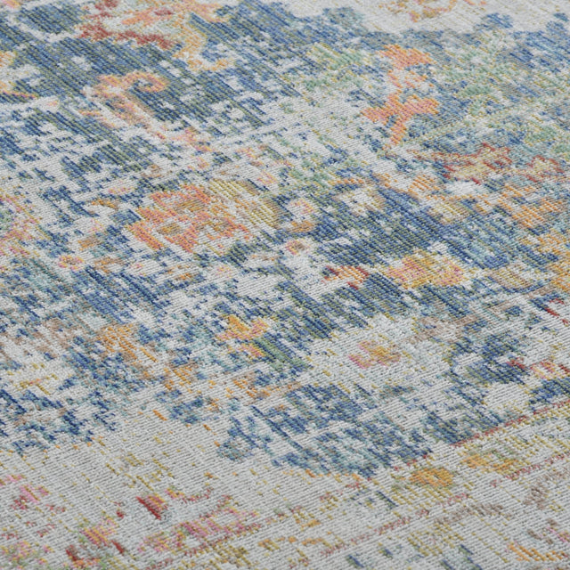 Close-up of indigo, ivory rug surface with multicolor distressed geometric pattern