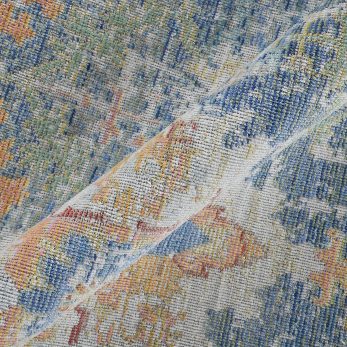 Close-up of ivory rug pile with indigo blue and orange vintage distressed detailing