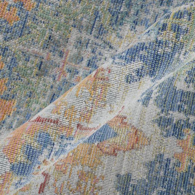 Close-up of ivory rug pile with indigo blue and orange vintage distressed detailing