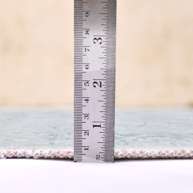 Sea mist area rug edge shown with measuring ruler at the rug border