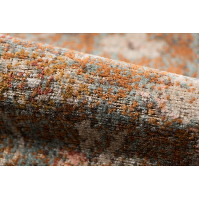 Textured edge of taupe medallion area rug with distressed multicolor woven pile