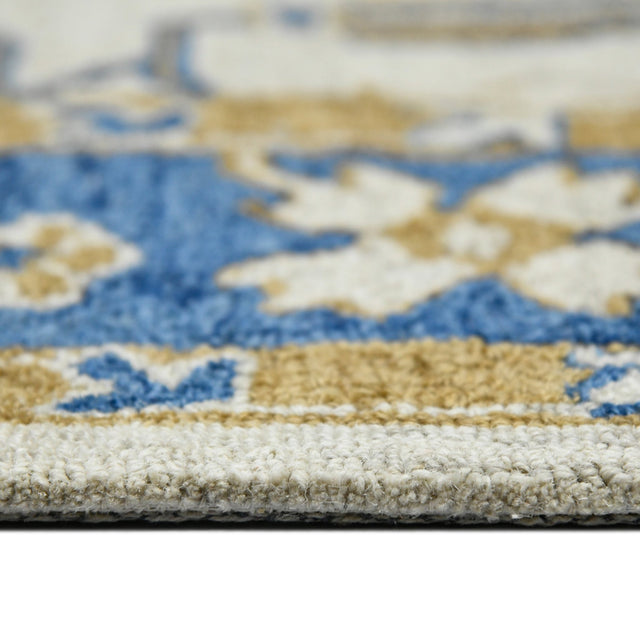 Hand-hooked floral area rug edge with textured pile in cream, royal blue, and gold