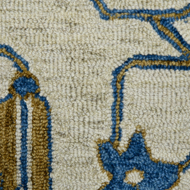 Hand-hooked floral area rug close-up of cream field with royal blue and gold patterned outlines