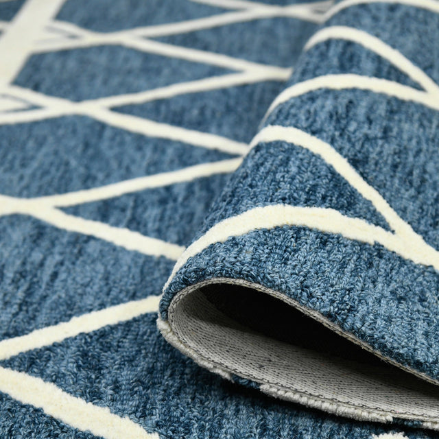 Rug edge with visible underside backing and cream-and-navy geometric pattern