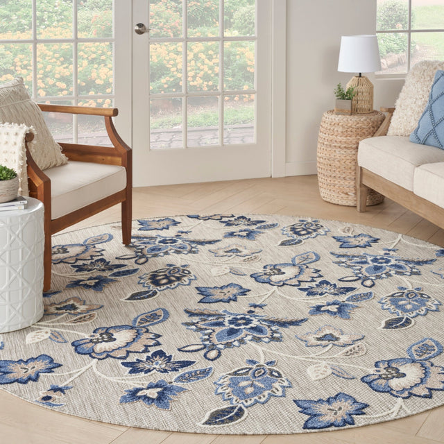 Blue-gray round rug with ornate floral and medallion pattern, soft woven texture