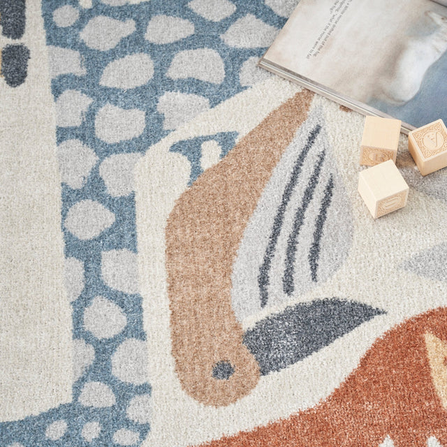 Ivory rug detail with blue geometric animal pattern and brown textured accents