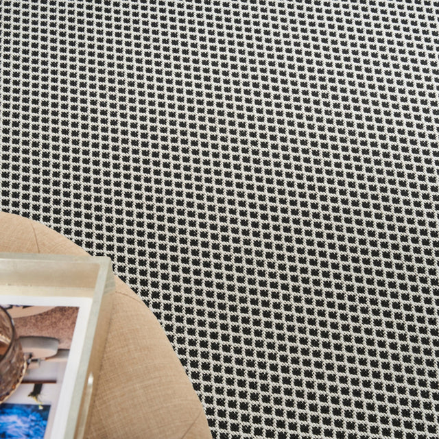 Close-up of black-and-white lattice rug texture with tight grid