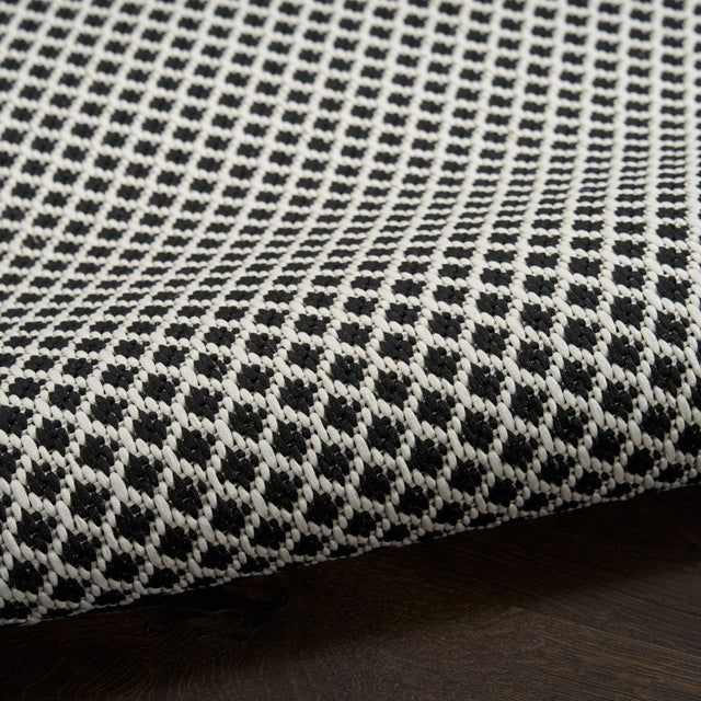 Black and white lattice rug with looped texture along the edge