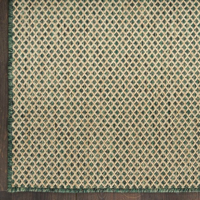 Green area rug close-up showing diamond lattice pattern with textured, flat weave