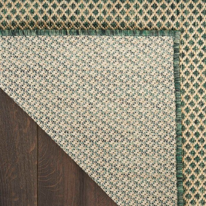 Green and beige rug corner with diamond lattice pattern and fringeless edge detail