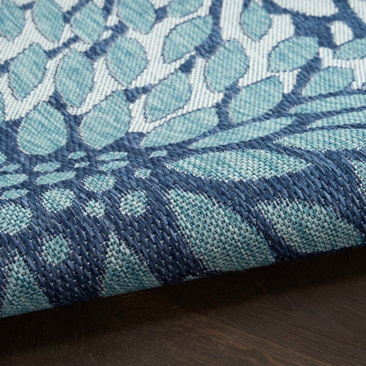 Navy and light blue area rug close-up showing raised textured floral pattern