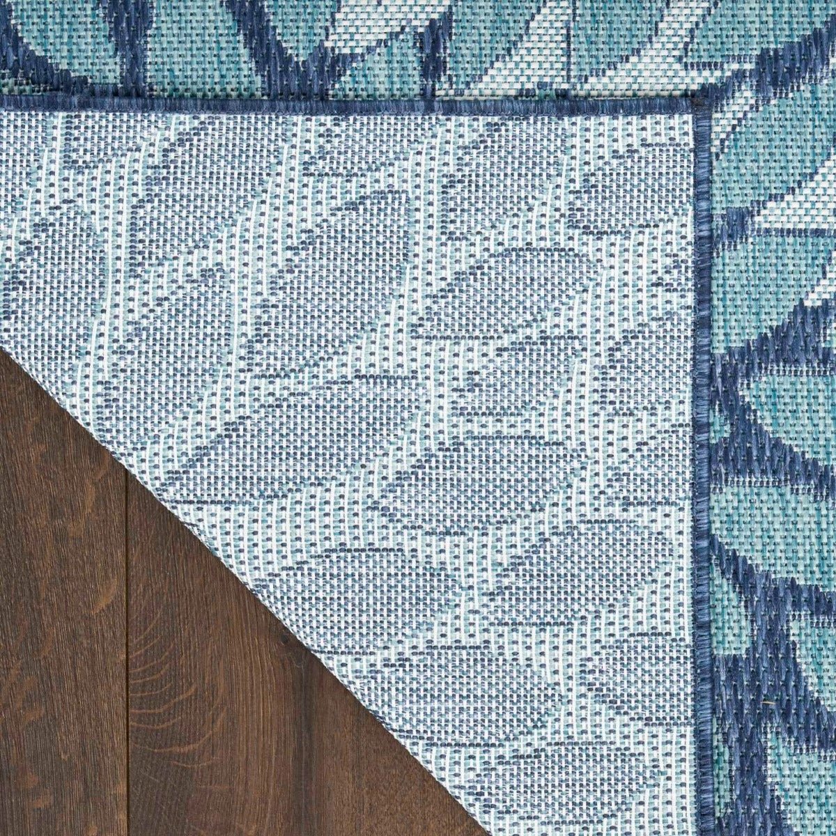 Navy and light blue area rug corner with white grid floral detailing and border
