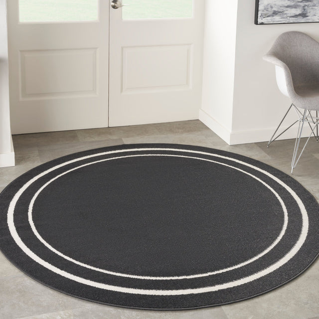 Black and ivory round rug with concentric oval stripes