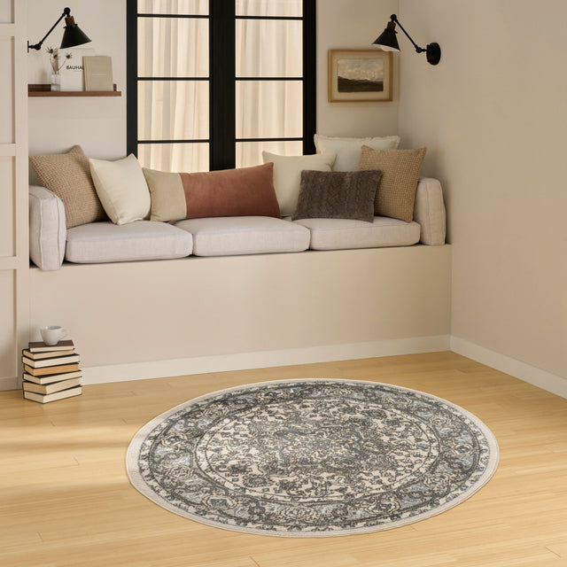 Round ivory and blue rug with detailed damask-style medallion motif
