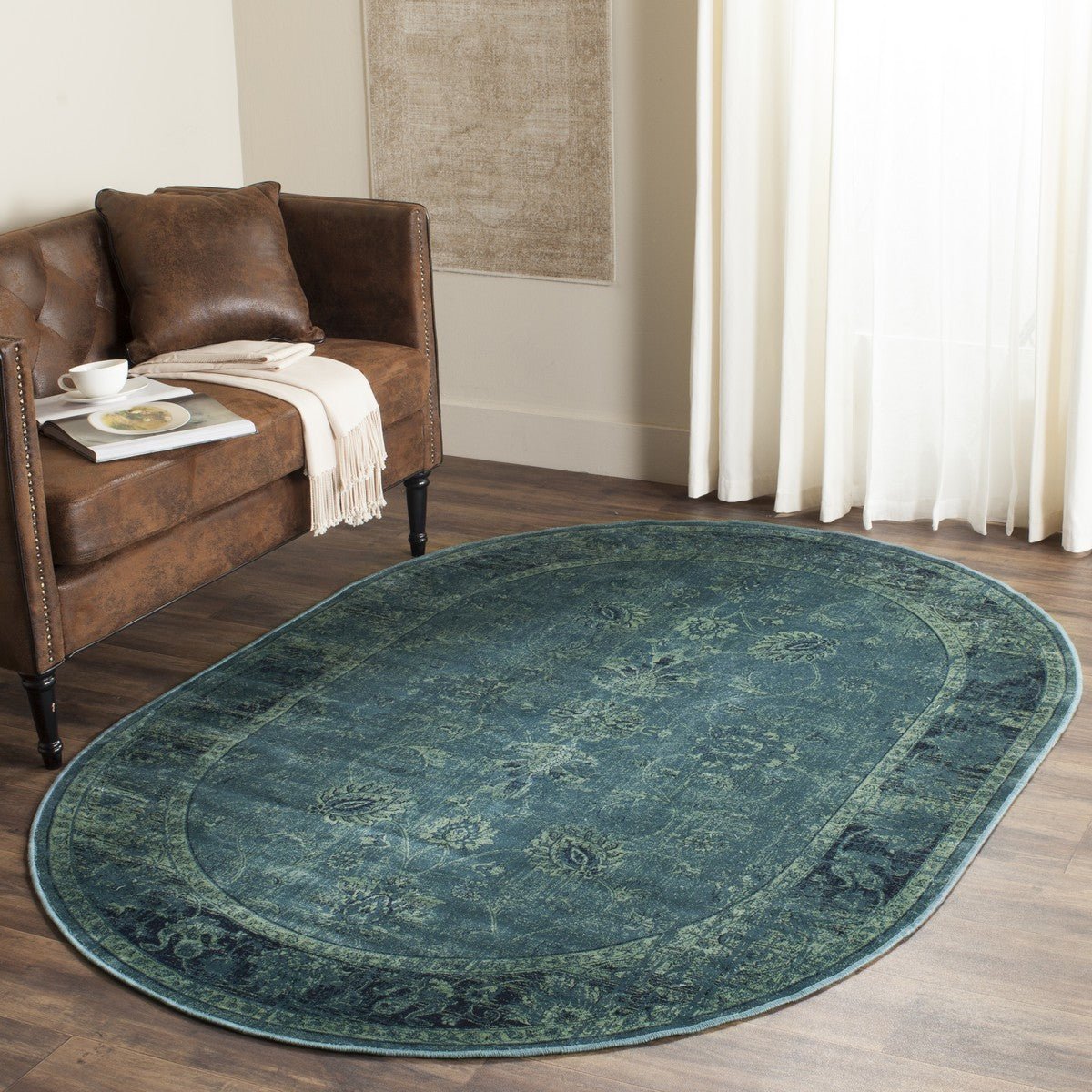 Vintage-style oval rug in dark teal with central medallion and decorative edge