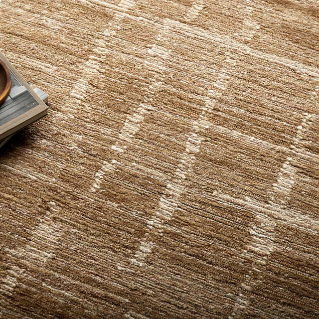 Textured handmade rug with tan base and scattered cream geometric pattern