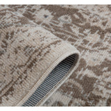 Corner close-up of rug with cream binding and blue-gray woven backing visible from edge.