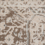 Close-up of light cream rug with taupe and brown abstract pattern and distressed look.