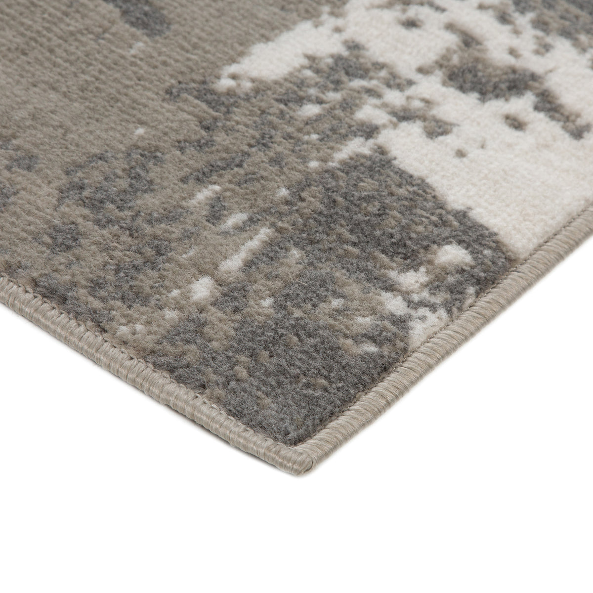 Ivory and dark gray rectangular area rug with abstract medallion pattern and fringed edge.