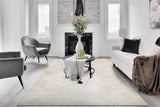 Modern geometric rug in light grey and ivory with subtle pattern and stitched edge
