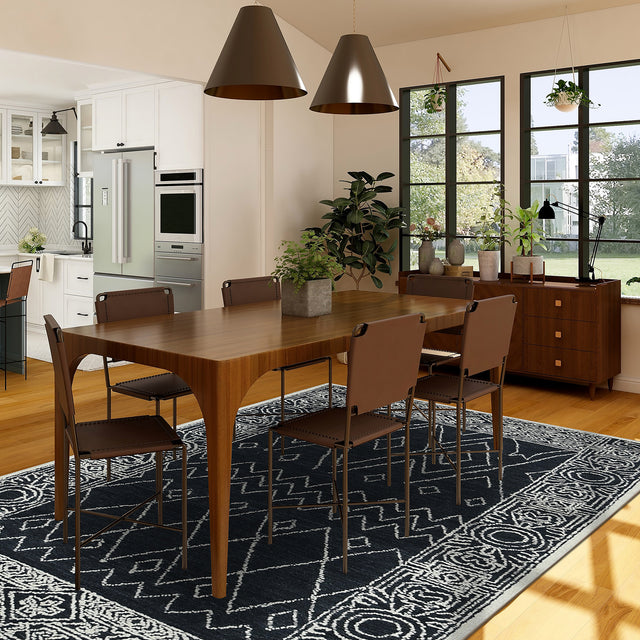 Rectangular area rug with charcoal/white geometric hand-hooked pattern, shown in a room