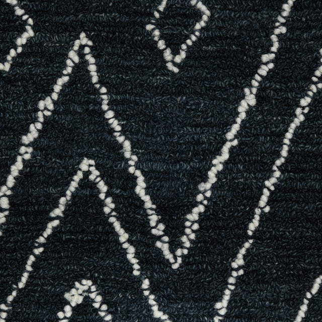 Rectangular area rug close-up of raised looped weave in dark navy-charcoal with white pattern