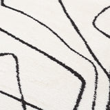 Close-up of ivory area rug with black contour lines forming angular shapes