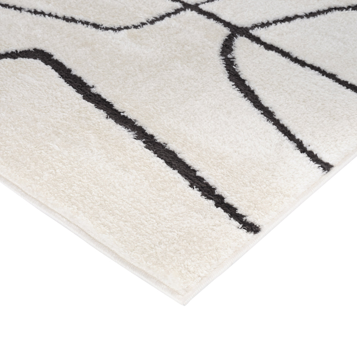 Ivory area rug with bold black geometric pattern and flat, finished corner edge