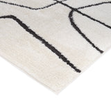 Ivory area rug with bold black geometric pattern and flat, finished corner edge